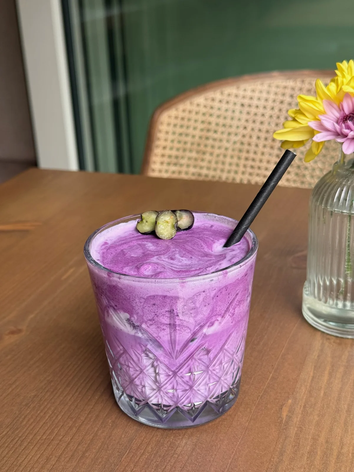 Violetter Drink mit Blütendekoration